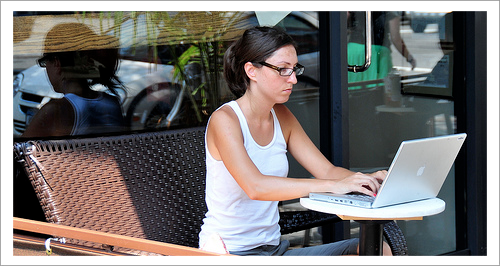 woman typing on a laptop at a coffee shop
